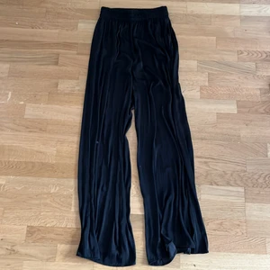 Byxor  - Så gott som nya. Säljer dessa svarta ”satin” byxor. De har fickor på sidorna. Byxorna är mycket sköna. På sista bilden ser ni hur tyget ser ut, då jag håller upp ena byxbenet med min hand.💗 När jag köpte byxorna kostade de 199kr men nu säljer jag de för 150kr.