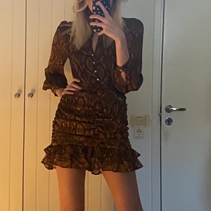 Mönstrad klänning  - En brun/guld ormskinnsmönstrad klänning från zara som jag säljer då den är för kort på mig som är 178cm. Jätte fin i fint skick. Köparen står för frakten och priset kan diskuteras. 