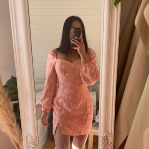 Rosa klänning från nelly - Säljer denna superfina slutsålda, rosa/aprikosfärgade klänningen från nelly med ”broderade” blomdetaljer🌸 Den är lite stor för mig som vanligtvis har 34. Är osäker på om den kommer komma till så mycket användning💗 Endast provad! Nypris 599