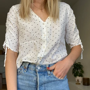 Prickig blus  - En fin vit blus med svarta prickar fram abercrombie & fitch. Den är croppad och går att knyta eller stoppa in i byxan. Sparsamt använd. 