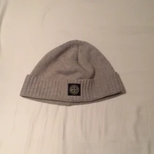 Stone island mössa junior - Stone island mössa storlek 3 bra skick knappt använd, köpt från Nk nypris runt 1000kr. Meddela om frågor. Äkta såklart.