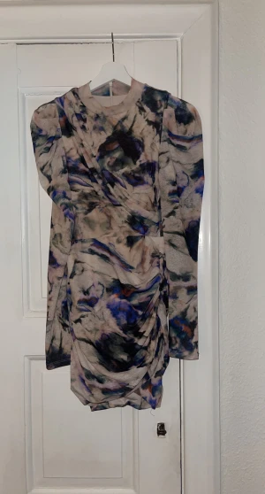 Nyårsklänning? - Mönstrad klänning från H&M i strl xs. Ärmarna är långa med lite puff på axlarna. Klänningen är åtsittande 