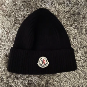Moncler mössa - Moncler mössa som passar både för tjejer och killar. Inköpspris: 2450kr, säljer för 950 kr