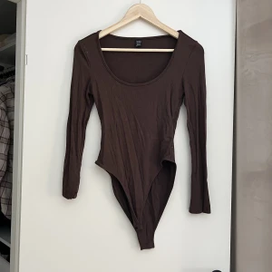 Body långärmad - Brun långärmad body från Shein strl. S. Oanvänd. 70 kr Samfraktar gärna! Kolla in mina andra annonser om det finns något av intresse!