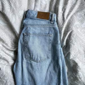 Blå högmidjade jeans med hål vid knäna från GinaTricot i modellen 90s high waist jeans