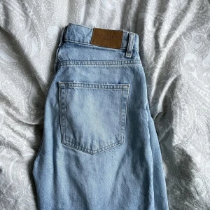 Blå jeans med hål - Blå högmidjade jeans med hål vid knäna från GinaTricot i modellen 90s high waist jeans