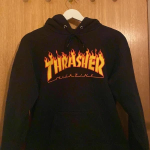 Thrasher hoodie - Jag säljer min thrasher hoodie då den inte passar längre. Ganska använd men fortfarande bra skick, dock är den lite sliten på ena snöret som man kan se på tredje bilden. 