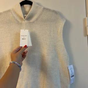 Väst Maja Nilsson lindelöf - Mysig oanvänd vit stickad väst från Maja Nilsson Lindelöfs kollektion med Gina. Längre modell med slits på sidorna. Storlek M, frakt tillkommer 