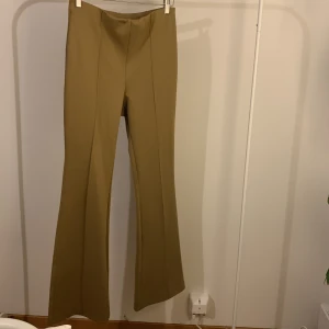 Utsvänga byxor i Beige. - Superfin utsvängd byxa i beige. Storlek M. 