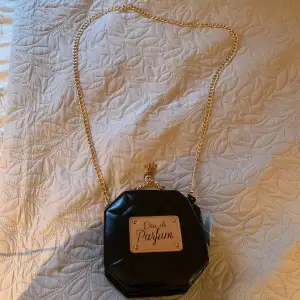 En parfym liknande väska med guld kedja som aldrig är använd!