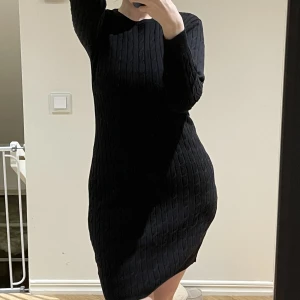 Kabelstickad klänning från gant  - Svart, kabelstickad klänning från gant. Saknar storlekslapp men skulle säga att den sitter fint på en storlek M/L, använd någon enstaka gång. 