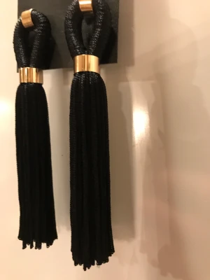 Öron hängen  - Svarta öron hängen, tofsar. Helt nya, aldrig använda. Kan skickas i brev, så billig frakt. 