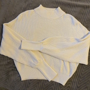 Vit Stickad Tröja Från  NA-KD  - En vit stickad tröja från NA-KD i storlek S men ganska oversized. Jätte fint skick, använd ett fåtal gånger.  Kan mötas i Malmö annars står köparen för frakten✨