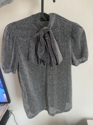 Glittrig knytblus  - Storlek small 