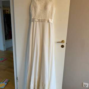 Short sleeved, off-white wedding gown with embroidery on the chest, and a long train. Selling to clear out some space in the closet. It’s in perfect condition.