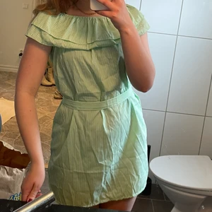 Sommarklänning - En superfin sommarklänning som man kan ha off-shoulders om man vill. Grön- och vitrandig. Följer med ett band som man kan knyta i midjan, annars är den fin utan också. Storlek XL men sitter som en S-M💗 
