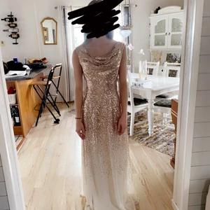Balklänning/festklänning  - Jag säljer min fina klänning som jag hade på balen. Använd 7 timmar. Den är ljus/beige och glittrig. Dras upp och ner med en dragkedja på sidan. Jag är 164 cm och den passade perfekt när jag hade klackskor på mig. Jag har storlek XS/S.