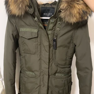 Hollies vinterjacka  - Jätte fin hollies jacka som jag väljer att sälja pågrund av att den bara står i garderoben. Väldigt bra skick då jag har köpt en ny vinterjacka och inte haft möjlighet att använda den så mycke. Pälsen är äkta, är i storlek 34 och slutar precis under baken för mig som är 160 cm. Jackan är givetvis äkta och är köpt i mall of scandinavia😊