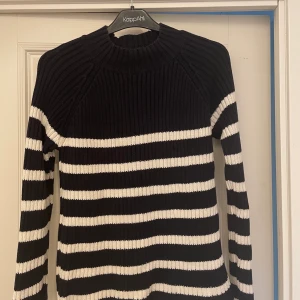Tröja  - Randig marinblå och vit stickad tröja från Lindex. Använd men i gott skick. Ordinarie pris: 399kr. Tröjan är lång i armarna med en hög krage. Mjuk bommulsblandning. Normal i storleken. 