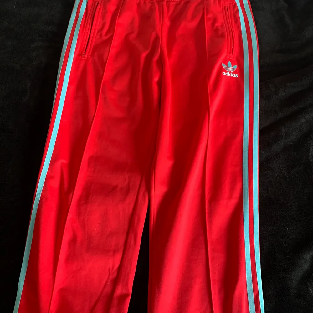 Säljer ett par cerisefärgade adidasbyxor. Detaljerna (ränderna och adidasmärket) är turkosblåa. Dem är mer cerise i verkligheten än dom ser ut att vara på bilderna. Stl 40. . Jeans & Byxor.