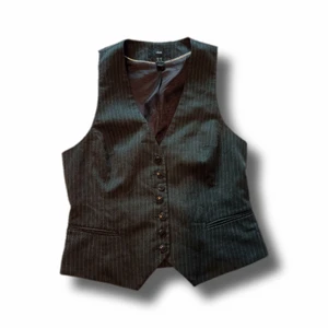 Väst - En svart/grå kostym väst! Den är randig, figursydd och har spänne på baksidan. Västen är från h&m och är i storlek 38. Väldigt fint bas-plagg, passar verkligen med allt🌹