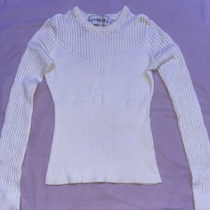 Vit tröja  - En vit tröja med små hål i, man kan ha på sig ett linne under så det inte blir så kallt. Tröjan är mycket bekväm och sitter bra på kroppen. Plus frakt!!