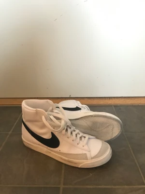 Nike Blazer storlek 43 - Säljer ett par blazers eftersom de var lite stora. Storlek 43. Har endast gymmat några få gånger i dom. De är Lite svarta på sulan annars i fint skick! Köparen står för frakten📦 