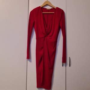 Röd ribbad klänning med knyt-detalj i midjan från Nelly, lite större i modellen, strl 36.
