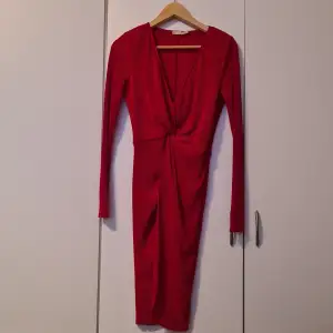 Röd ribbad klänning med knyt-detalj i midjan från Nelly, lite större i modellen, strl 36.