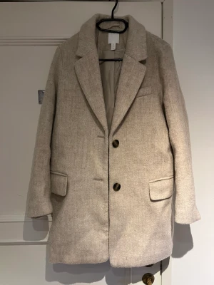 Kappa - Beige kappa i storlek xs från H&M. Väldigt fint skick då den endast är använd ett fåtal gånger. Tyvärr är det hål i fickornas innertyg, men detta går ju att åtgärda om man vill. 