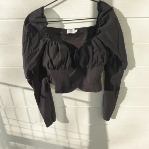 Kort Topp med Puffärm Strl. 42 (Ny!) - Säljer en helt ny topp från Na-Kd i Strl. 42. Materialet är utan stretch och har en dragkedja i sidan. Toppen är superfin så jag hoppas att den välkomnas i någon annans garderob. :) 