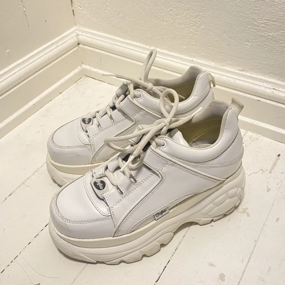 Buffalo London platå vita skor i storlek 38.  Skorna är använda men i bra skick med några mindre synliga repor  799:- exkl frakt . Skor.