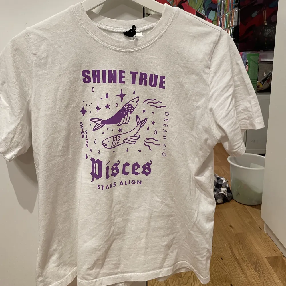Vit t shirt med lila tryck av stjärntecknet fisken, använd fåtal gånger! Bra skick! . T-shirts.