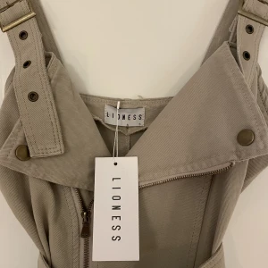 Lioness klänning - Oanvänd med lapp kvar! Beige jeansklänning från Lioness, mini-längd.