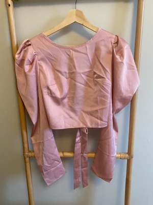 Topp från Shein aldrig använd med puffärmar och knytning i ryggen - Så fin rosa topp/blus från Shein jag aldrig använt med rosa puffärmar och fin knytning i ryggen. Storlek S