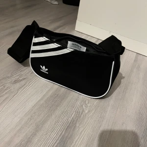 Adidas väska  - Denna väska är från adidas och har ett justerbart band. Kommer sälja denna för 100kr!