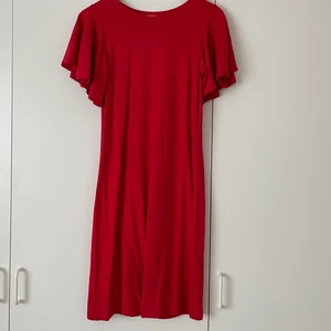 Röd klänning  - En röd halvlång t-shirt klänning med volang i ärmarna! 