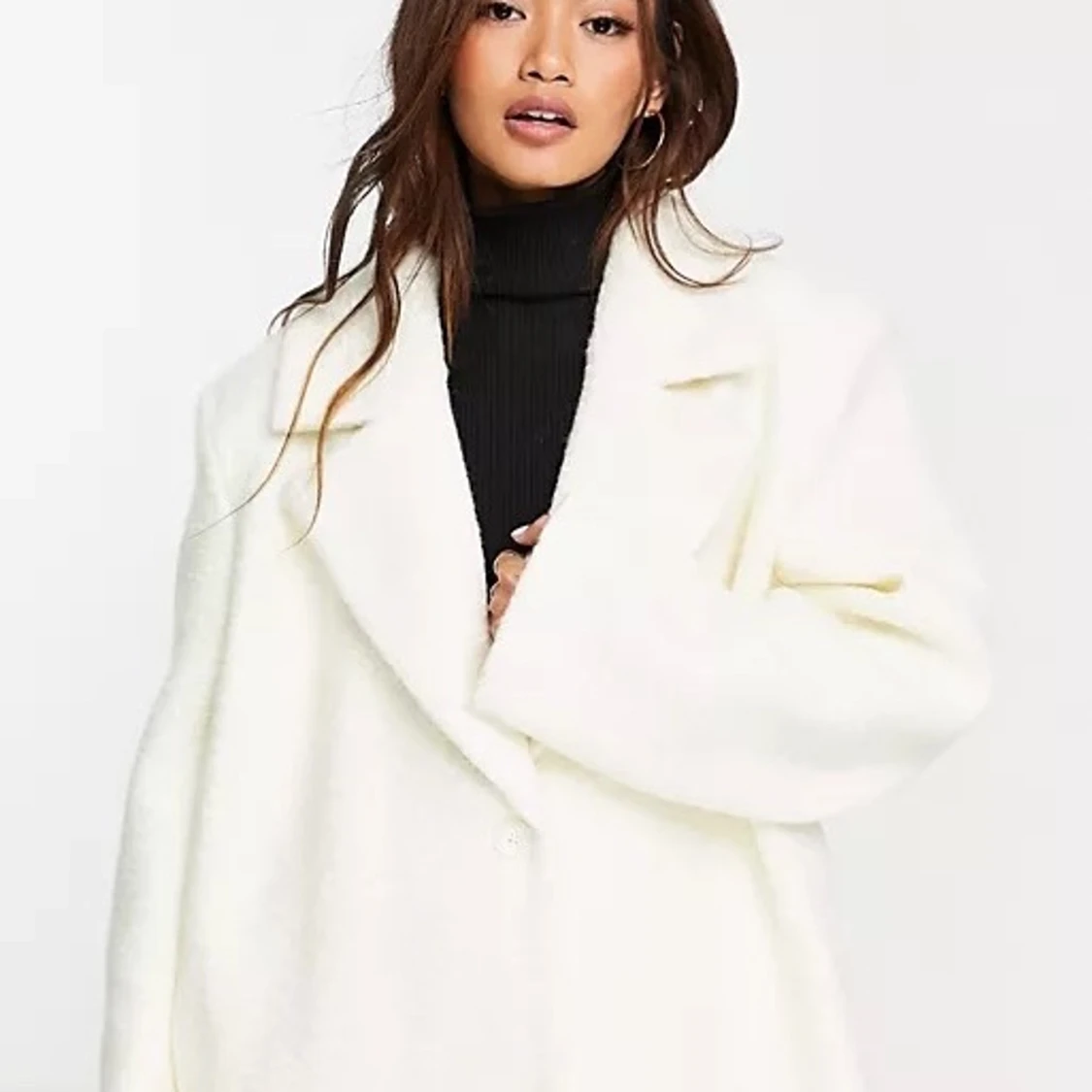 En vit kappa som slutar vid fötterna