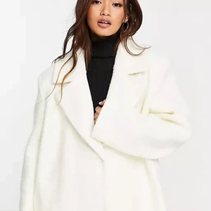 En vit kappa som slutar vid fötterna  - En vit stor lång kappa från NA-KD slutar vid fötterna, bara använd en vinter säljer den för jag börjar få för mycket jackor hemma och ska köpa en ny till vintern, den har inga fläckar eller skador på sig 