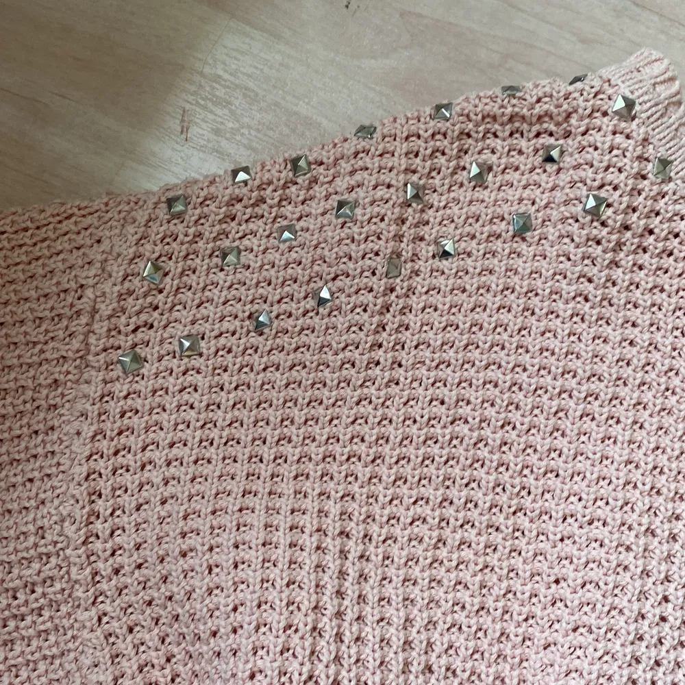 En rosa sweatshirt som är stickad med nitar på axlarna. Tröjor & Koftor.