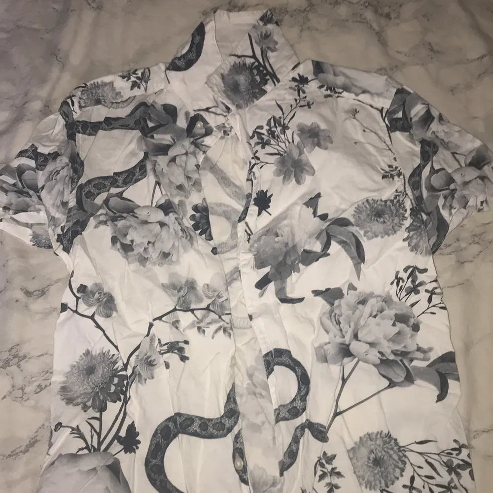 Skjorta med mönster av orm och blommor . Skjortor.