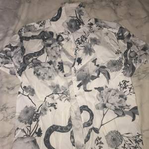 Skjorta med mönster av orm och blommor 