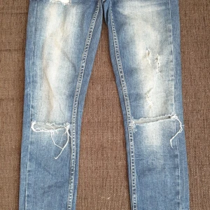 Kristen låga jeans med slitningar, dragkedja vid anklarna - Snygga jeans i fint anv skick