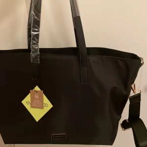 Svart handväska  - En snygg och praktisk handväska med axelband från even & odd. den har dragkedja, innerfack utan dragkedja samt innerfack med dragkedja. Den är oanvänd med prislappen kvar. 💗💓Bredd: 48cm, höjd 30cm, djup ca 15cm. ( nypris 240kr)