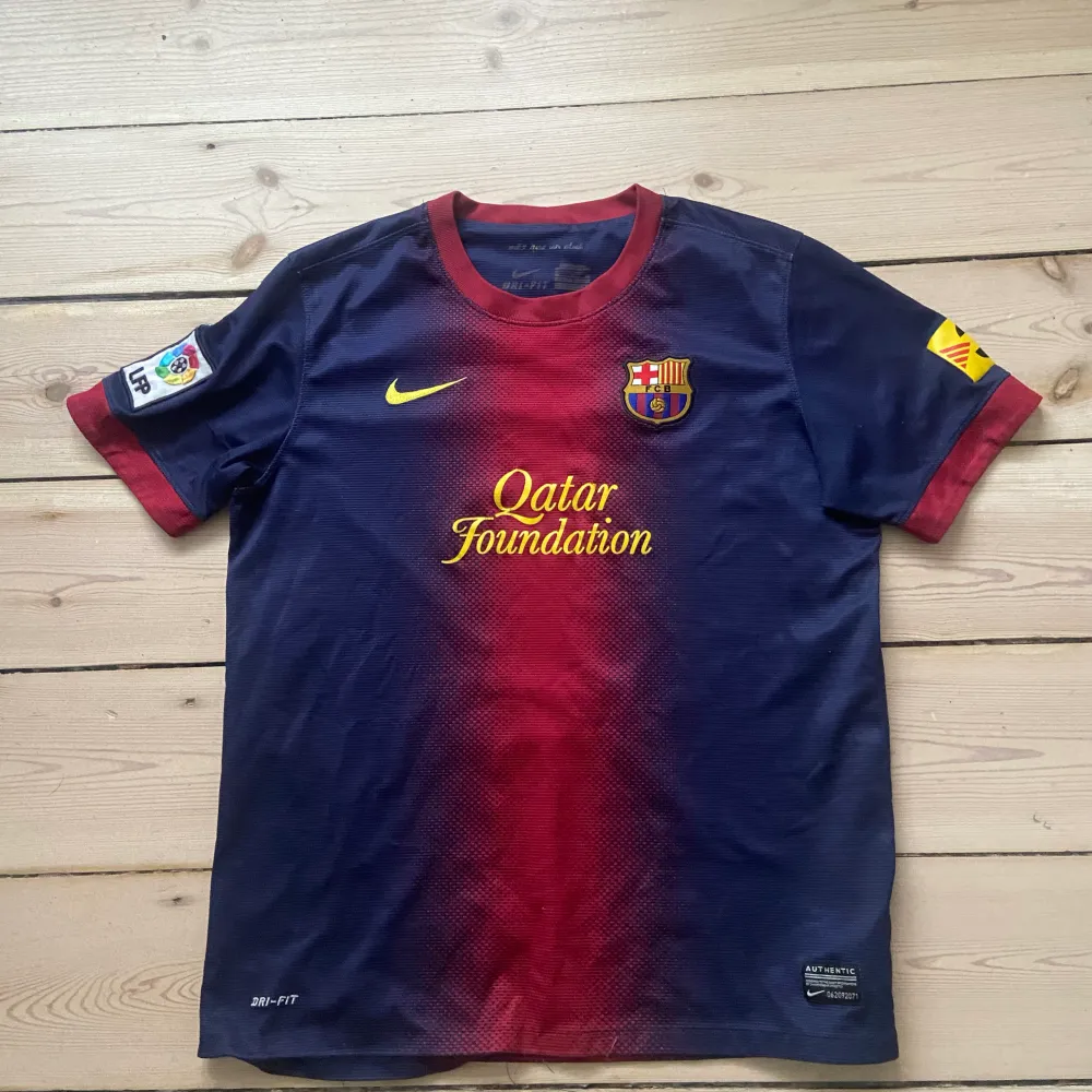 Super fin Barca spillertrøje fra en lidt ældre sæson. Der er et laliga emblem på det ene ærme . T-shirts.