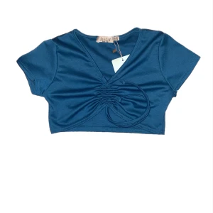 Topp - Croppad grön/blå topp med en ”knyt” detalj. Aldrig använd!