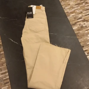 Jeans - Helt nya beiga jeans med etikett på . Modell : Slim Flare St: 36
