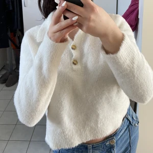 Vit fluffig skjorta - Vit fluffig långärmad tröja med skjortkrage. Super mysig och mjuk i materialet, köpt via ASOS för kanske 1 år sedan. Sitter inte alls tight runt mage eller armar 💕