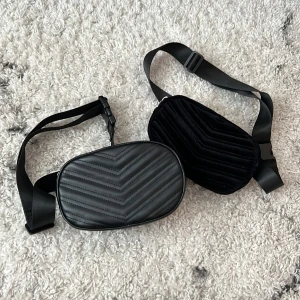 Magväskor - Svarta magväskor från H&M. Den ena är i imitations läder och den andra i sammet. Som nya.   19 cm breda och 12 cm höga.   Båda för 50 kr