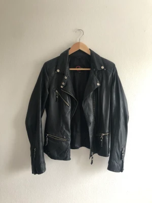 Tunn läderjacka - Cool tunn läderjacka. Köpt second hand men aldrig använt själv hehe. Den fläckigt parti på vänstra sidan och några fläckar på höger sida av kragen (se sista bilden), vet inte om det är missfärgat eller skulle gå bort i tvätt.